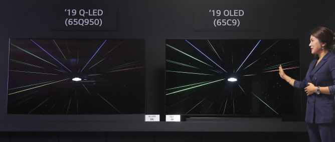 An LG Electronics official compares LG's OLED TV with Samsung's QLED TV during a technology briefing at LG Twin Towers in Seoul on Sept. 17, 2019. (Yonhap)