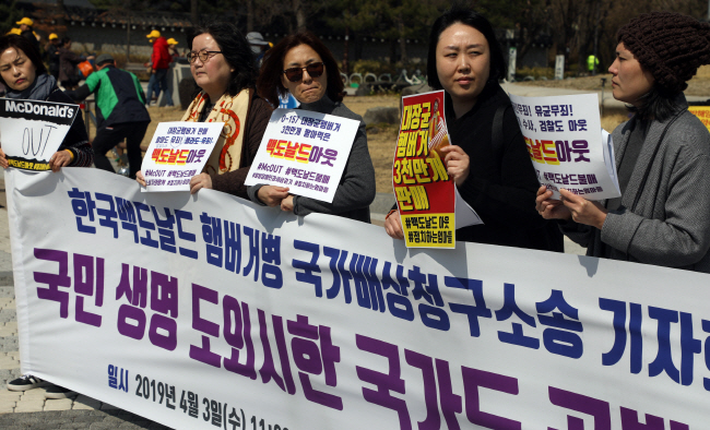 A civic group holds a press conference in front of the presidential office Cheong Wa Dae on April 3, 2019, accusing McDonald's Korea of being responsible for the so-called burger patty scandal. (Yonhap)