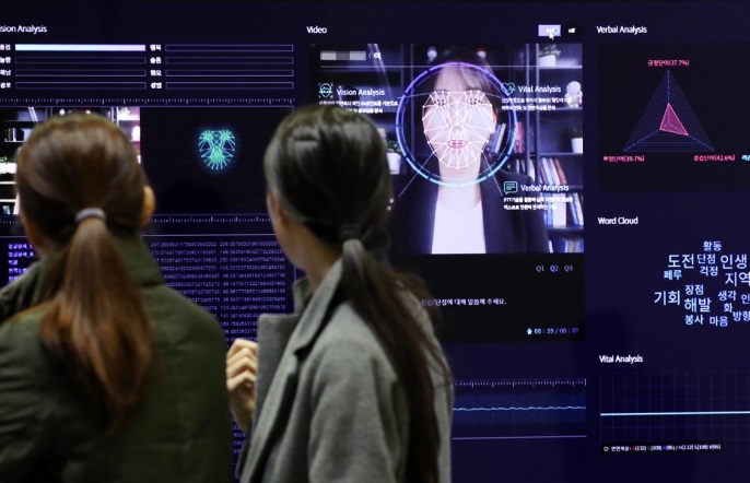 Jobseekers watch an artificial intelligence video analysis solution for the hiring process at the job festival in Seoul. (Yonhap)