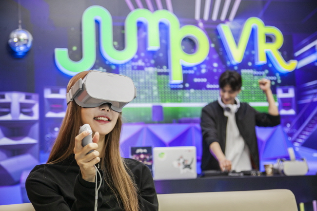 Models enjoy SK Telecom Co.'s Virtual Social World, a virtual reality (VR) playground, with the VR headset Oculus Go. (image: SK Telecom)