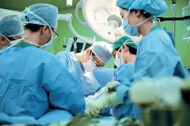 This undated photo provided by Asan Medical Center shows doctors in surgery.