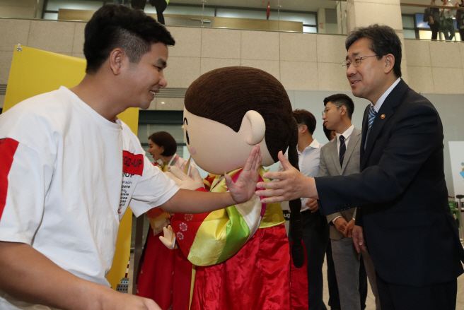 Minister of Culture, Sports and Tourism Park Yang-woo (R) greeting a foreign visitor arriving at Incheon International Airport, west of Seoul. (Yonhap)
