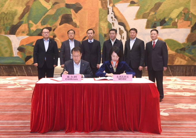 This photo, provided by Celltrion Inc. on Jan. 21, 2020, shows CEO Gi Woo-seong (L at table) with an official from the Donghu New Technology Development Zone signing an agreement.