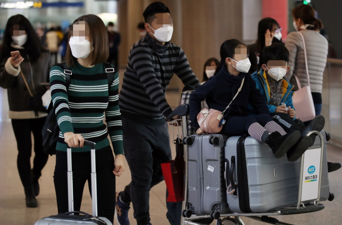 Tourists wearing masks walk at Incheon International Airport, west of Seoul, on Jan. 28, 2020. (Yonhap)