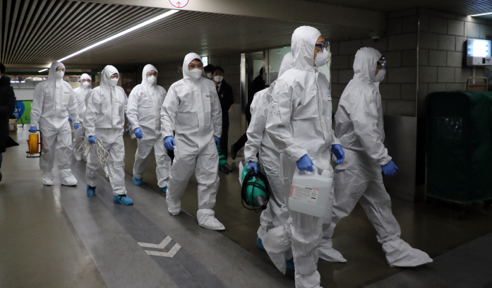 Workers from a disinfection service company enter Lotte Department Store in central Seoul on Feb. 7, 2020, after it was temporarily closed for a cleanup following a recent visit there by a patient diagnosed with the new coronavirus. (Yonhap)
