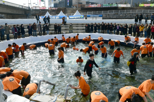 This file photo provided by Hwacheon County Office shows tourists enjoying bare hand fishing in Hwacheon, northeast of Seoul, during the 2020 Hwacheon Sancheoneo Ice Festival.