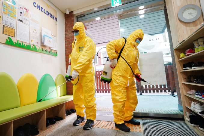 This image, provided by the Dongdaemun Ward office in Seoul, shows officials disinfecting a child care center in the area.