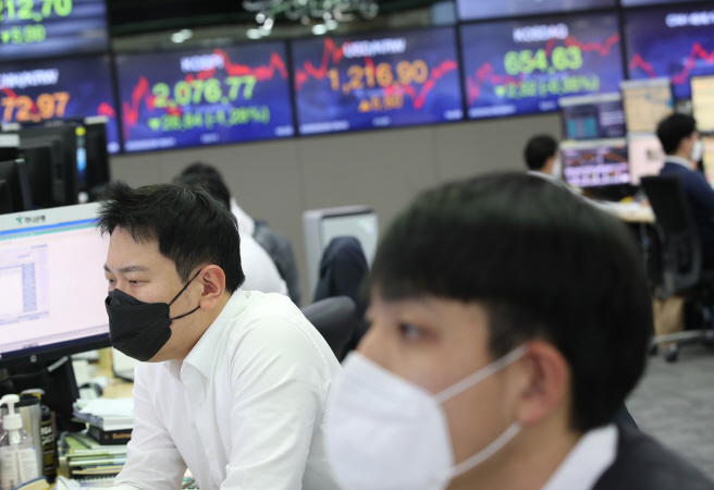 Currency dealers wearing masks work in the trading room of Hana Bank's headquarters in Seoul on Feb. 26, 2020. (Yonhap)