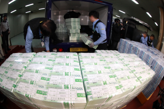 Officials at a Seoul branch of the Bank of Korea prepare new banknotes for their release. (Yonhap)