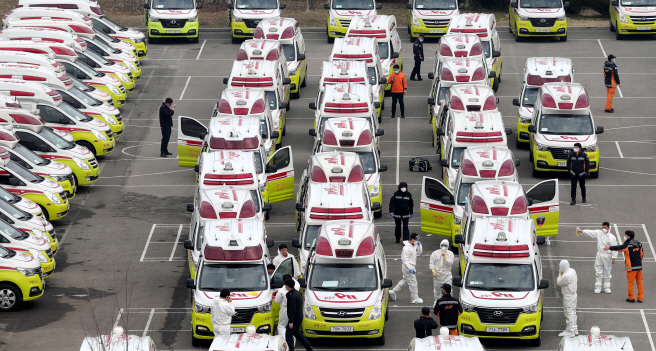 Ambulances are parked outside a water purification plant in Daegu on March 1, 2020, with emergency workers checking their vehicles. (Yonhap) 
