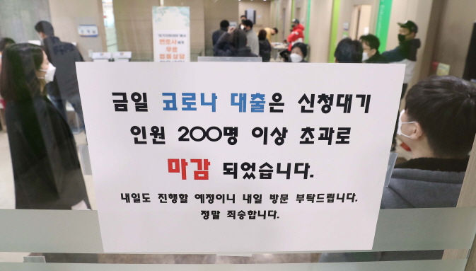 A makeshift signboard at a bank in Daegu, one of the epicenters of the new coronavirus in South Korea, located some 300 kilometers south of Seoul, on March 4, 2020 says the line for counseling on special loans for businesses hit by the virus outbreak has closed for the day with more than 200 people already standing in line. (Yonhap)