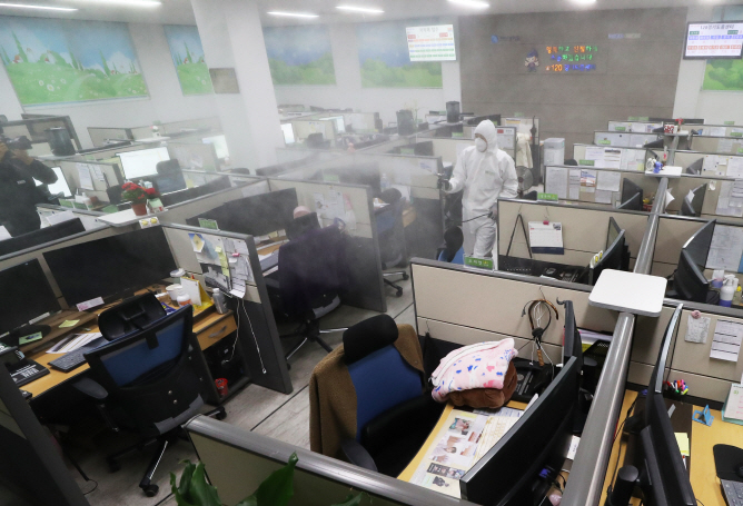 A health worker disinfects an office room at a call center in Suwon, south of Seoul, on March 11, 2020. (Yonhap)