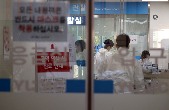 This file photo taken on March 18, 2020, shows medical staff in protective suits working at a hospital emergency room in Daegu, 300 kilometers southeast of Seoul. (Yonhap)
