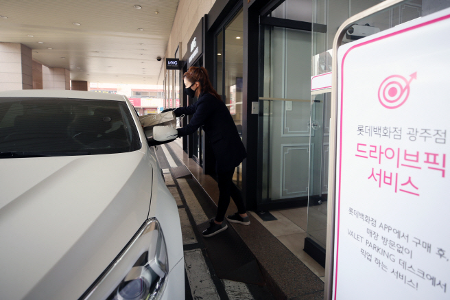 A driver picks up his order inside a car from an employee at Lotte Department Store in Gwangju, 329 kilometers south of Seoul on March 19, 2020, amid the spread of the new coronavirus. (Yonhap)