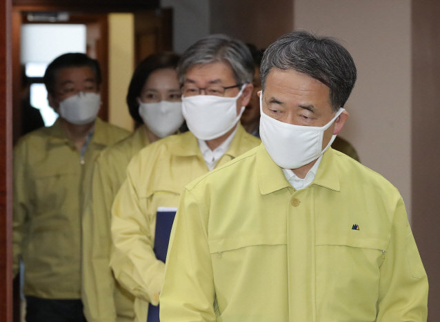 Minister of Health and Welfare Park Neung-hoo (front) walks into a conference room for a government meeting on responding to the coronavirus outbreak, held at the government office complex in Seoul, on March 22, 2020. (Yonhap)