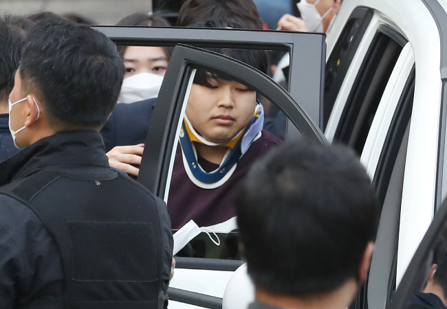 Cho Ju-bin is taken into a car at a police station in Seoul on March 25, 2020, before being sent to prosecutors on allegations that he blackmailed dozens of victims into performing violent sex acts and sold the content in a mobile group chat room on the messaging service Telegram. (Yonhap)