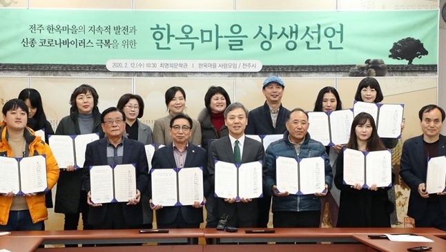 This file photo shows landlords of Jeonju Hanok Village posing with a written agreement to cut rents by up to 20 percent. (Yonhap)