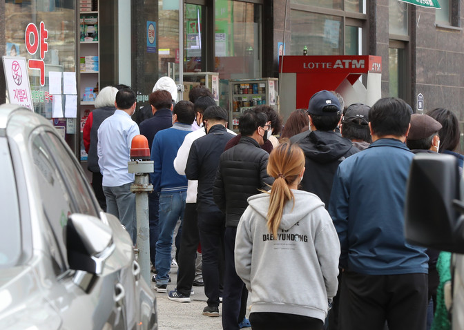 People line up to buy masks -- two per person, in line with government guidance -- at a pharmacy in Guro Ward, southwestern Seoul on March 28, 2020. (Yonhap)