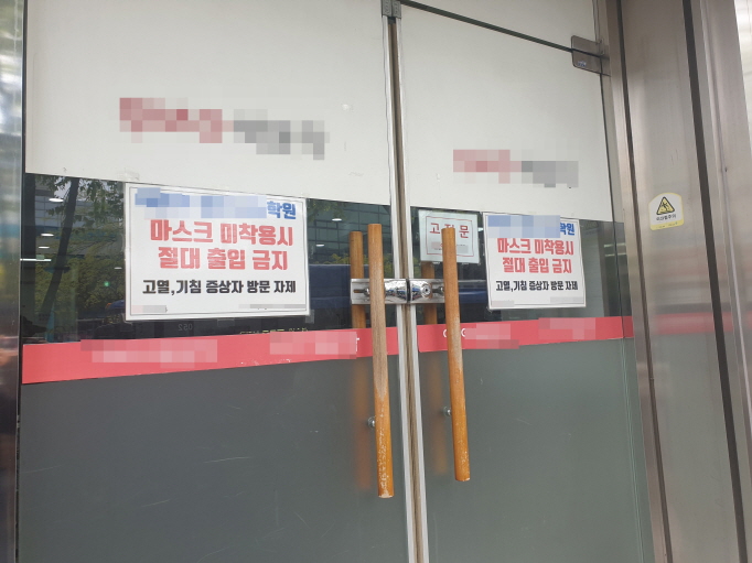 A signboard reading "No access without face masks" is posted on the gate of a cram school in Dongjak Ward, southern Seoul as it resumed operations on April 20, 2020, amid relaxed social distancing rules. (Yonhap)