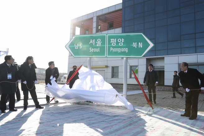Participants unveil a road sign during a groundbreaking ceremony for a project to modernize and connect roads and railways over the border between the Koreas at Panmun Station in the North's border town of Kaesong on Dec. 26, 2018, in this photo provided by the ministry.