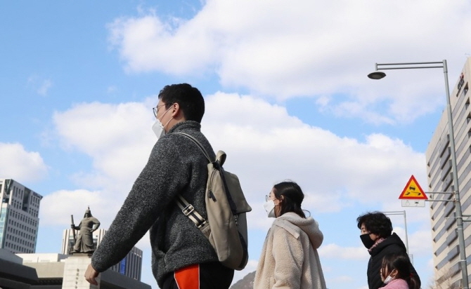 This file photo taken Feb. 27, 2020, shows mask-wearing citizens walking in downtown Seoul under a clean sky. (Yonhap)