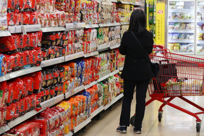 A consumer browses shelves stocked with instant noodle products at a supermarket in Seoul on April 6, 2020. (Yonhap)