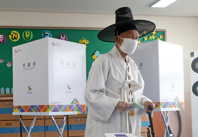 A teacher in traditional Korean attire votes in the quadrennial general elections at an elementary school in South Chungcheong Province on April 15, 2020. (Yonhap)
