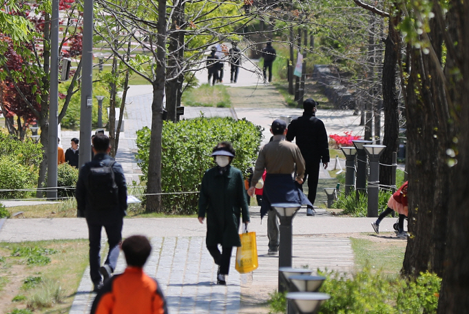 Citizens wearing face masks walk in a park in Seoul on April 24, 2020. (Yonhap)