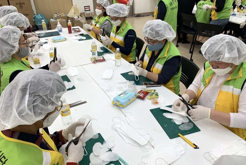 This photo, provided by a social enterprise for the hearing-impaired in Daejeon, 164 kilometers south of Seoul, on May 21, 2020, shows volunteers making transparent masks that enable hearing-impaired students to see their teachers' mouth movements.