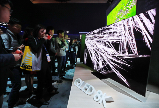 This photo taken on Jan. 8, 2020, shows people looking at Samsung Electronics Co.'s QLED 8K TVs at the company's exhibition booth at the Consumer Electronics Show in Las Vegas, Nevada. (Yonhap)