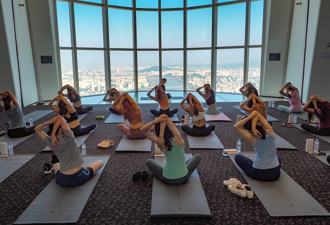 This photo taken on Aug. 14, 2019 and provided by Lotte World Tower & Lotte World Mall shows women in leggings participating in a yoga class at the country's tallest building in eastern Seoul. 