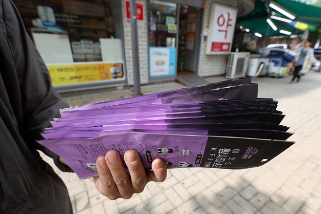 A customer holds a bundle of masks for himself and his family after purchasing them at a drugstore in Gwangju, 329 kilometers south of Seoul, on June 1, 2020. No standing in line was necessary. (Yonhap)