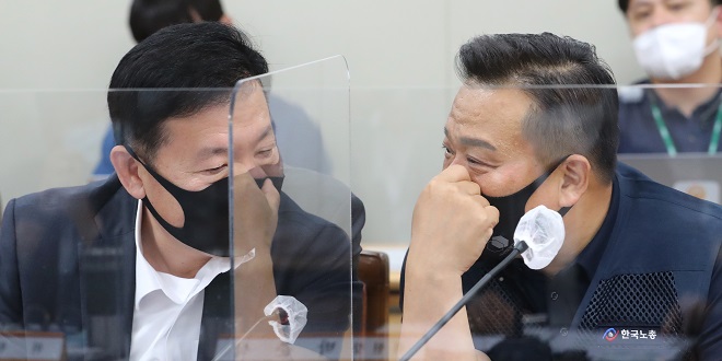Ryu Ki-jeong, an official at the Korea Enterprises Foundation (L), and Lee Dong-ho, the secretary general of the Federation of Korean Trade Unions talk to each other during the Minimum Wage Commission's plenary meeting held at the government complex in Sejong, south of Seoul, on June 11, 2020. (Yonhap)