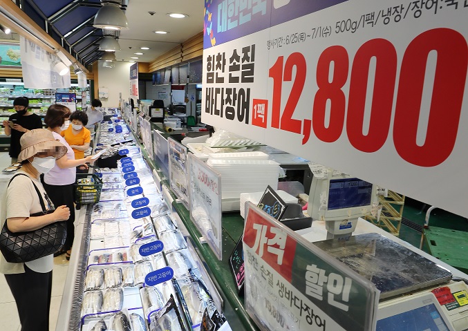 Shoppers browse eels at a supermarket in Seoul on June 26, 2020, as traditional markets, major retailers and department stores launched a state-led sales festival the same day as part of efforts to stimulate domestic consumption hit by the coronavirus pandemic. (Yonhap)