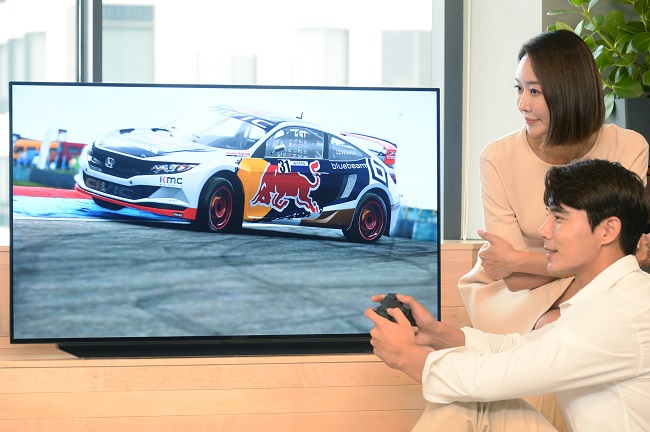 Models pose for a photo with LG Electronics Inc.'s 48-inch OLED TV, in this photo provided by the company on July 24, 2020. 