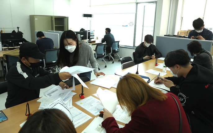 In the file photo, taken April 3, 2020, people are seen filling in application forms for special loans designed to support small businesses hit by the new coronavirus outbreak at a Seoul office of the Small Enterprise and Market Service. (Yonhap)