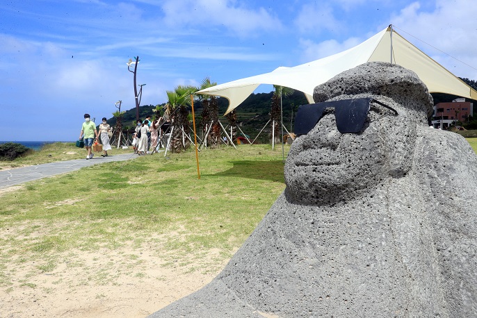 A “dolharbang” (stone grandfather) wears sunglasses at Hamdeok Beach in the city of Jeju on South Korea’s southern resort island of Jeju on June 21, 2020. (Yonhap)