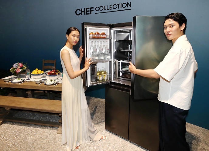 Models pose for a photo with Samsung Electronics Co.'s New Chef Collection refrigerator at a studio in Seoul on July 2, 2020. (Yonhap)