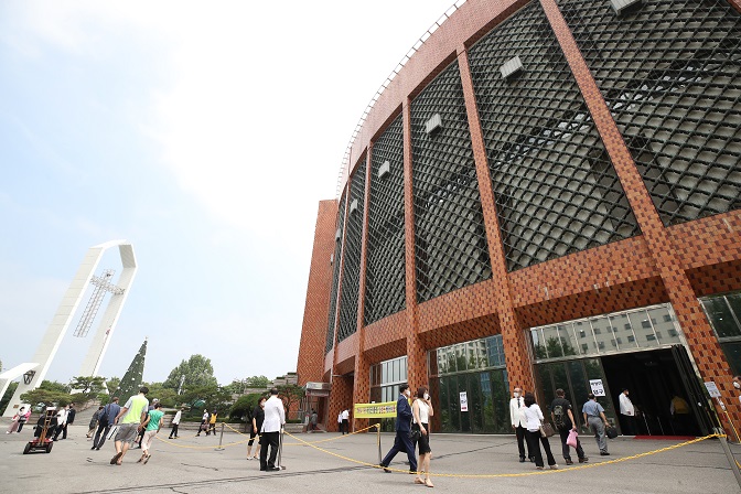 Church officials guide worshipers to keep a distance between them before entering the Yoido Full Gospel Church in Seoul for religious services on July 5, 2020. (Yonhap)