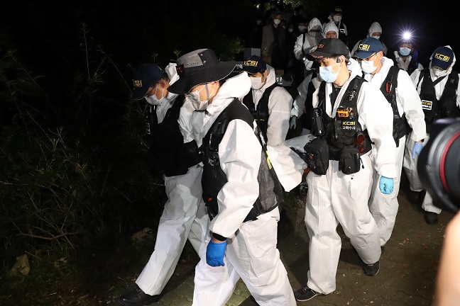 Police scientific investigation team members carry the body of Seoul Mayor Park Won-soon, who was found dead in the forested hills of Mount Bukak in Seoul on July 10, 2020. (Yonhap)