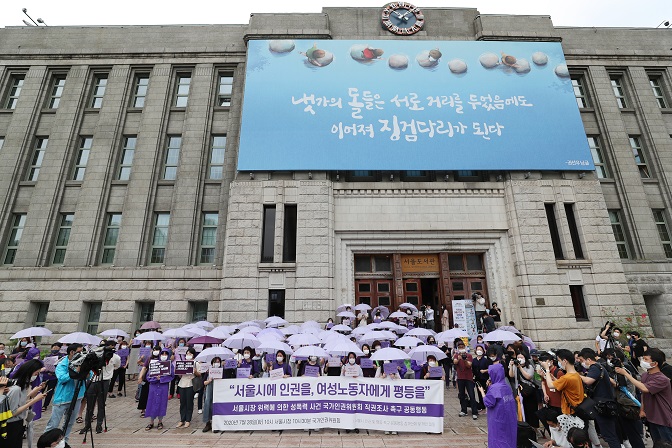 Participants, dressed in purple and holding violet-colored umbrellas, hold a press conference in front of Seoul City Hall in central Seoul on July 28, 2020, demanding a "proper investigation" into sexual misconduct allegations raised against late Seoul Mayor Park Won-soon. (Yonhap)