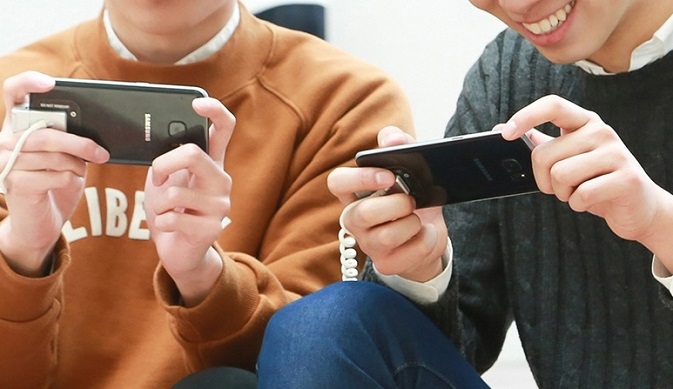 In this photo, provided by Samsung Electronics Co., users play a mobile game with Galaxy smartphones.