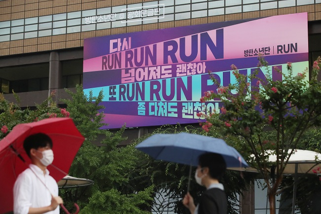 A large banner featuring part of the lyrics of BTS' "Run" is installed on an outer wall of a building at the Gwanghwamun square in Seoul on Aug. 3, 2020. (Yonhap)