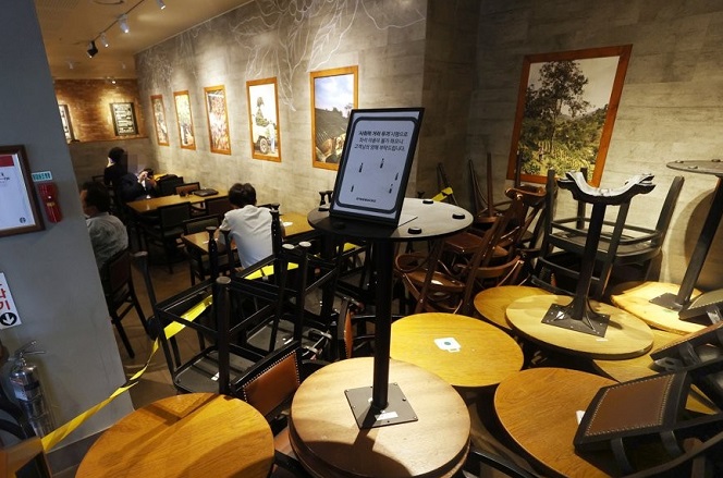 Chairs and tables are stacked up as part of social distancing measures at a Starbucks store in Seoul on Aug. 18, 2020. (Yonhap)