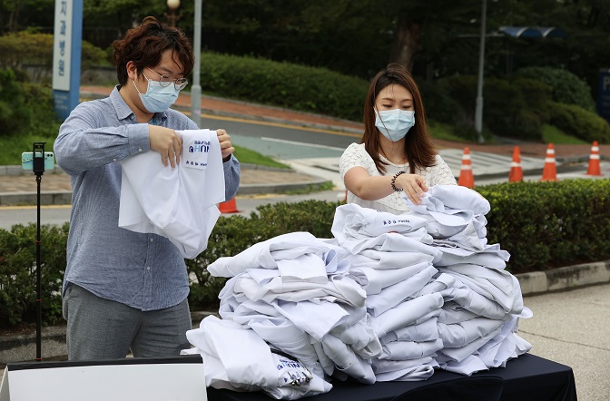 Trainee doctors at Seoul National University Hospital in Seoul stack up their white gowns on Aug. 23, 2020, in a protest of the government's plan to increase medical school admission quotas. (Yonhap)