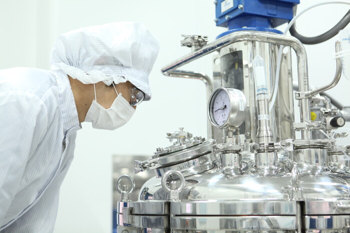 This undated photo, provided by South Korea's biotech company GC Pharma, shows a company official at its plant. 