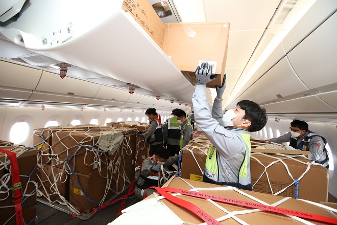This photo, taken on Sept. 24, 2020, and provided by Asiana Airlines, shows the carrier's employees loading cargo in its A350-900 jet at Incheon International Airport in Incheon, just west of Seoul.