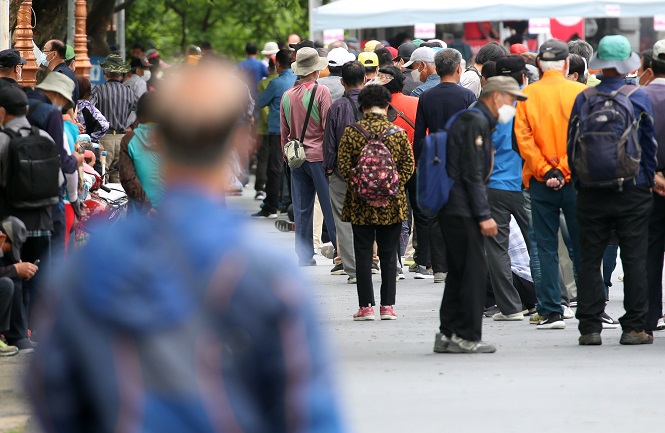 This file photo shows people waiting in line to eat at a free meal station in Daegu, 302 kilometers south of Seoul, on May 14, 2020. (Yonhap)