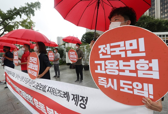 Officials affiliated with the progressive Jinbo Party hold a press conference on swiftly expanding state employment insurance to all citizens in front of the government complex in central Seoul on Aug. 28, 2020. (Yonhap)