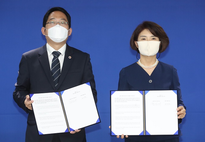 Korean Medical Association head Choi Dae-zip (L) and ruling Democratic Party policy committee chief Rep. Han Jeoung-ae hold up signed agreements outlining future talks to resolve the government's medical reform plan and end the strike by doctors, in Seoul on Sept. 4, 2020. (Yonhap)